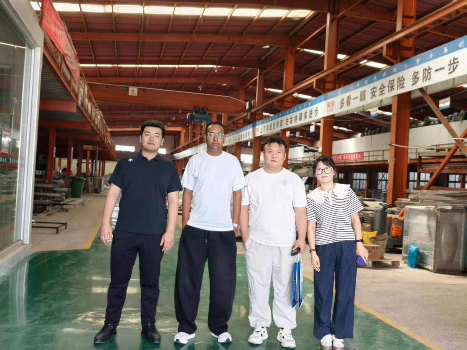 LVJIA staff and visiting buyers on the factory floor between sectional water tanks