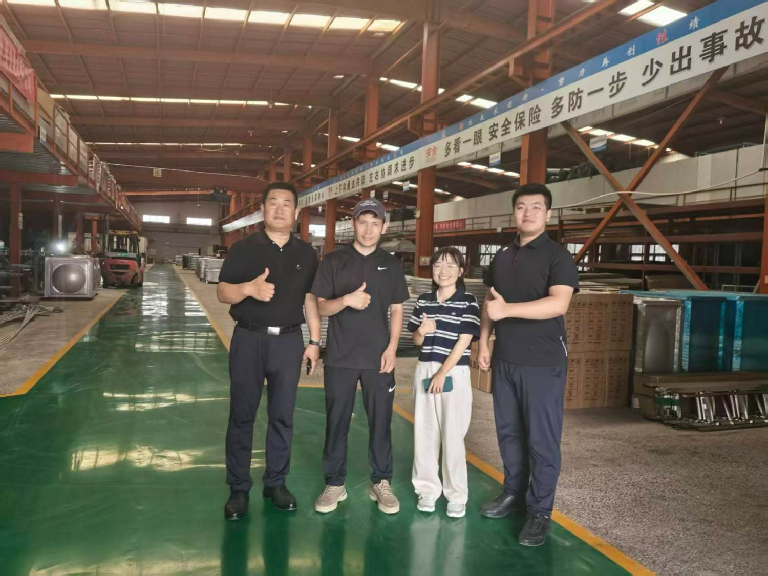 LVJIA team with a visiting buyer inside the water tank production hall