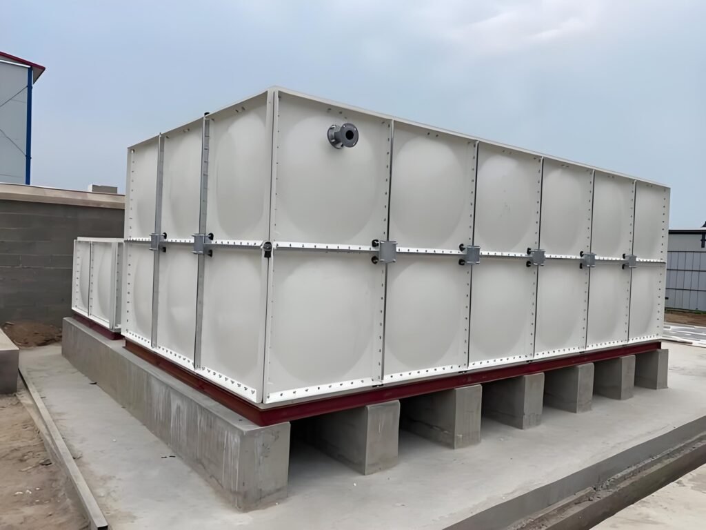 GRP sectional water tank with pipe fittings on concrete plinths