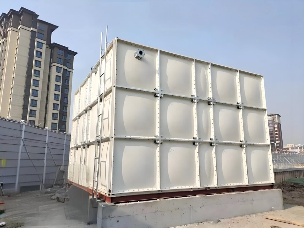 Tall GRP sectional water tank installed beside residential buildings