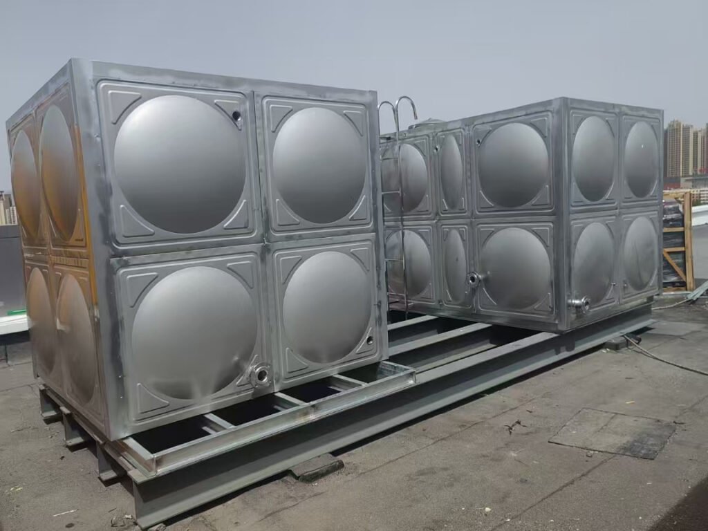 Two bolted stainless steel water tanks side by side on steel bases